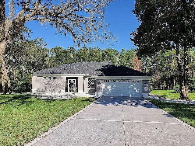 single story home with concrete driveway, a front lawn, and an attached garage