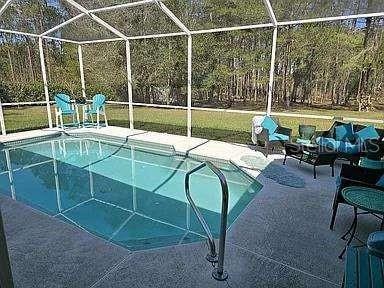 outdoor pool featuring a patio area and a lanai