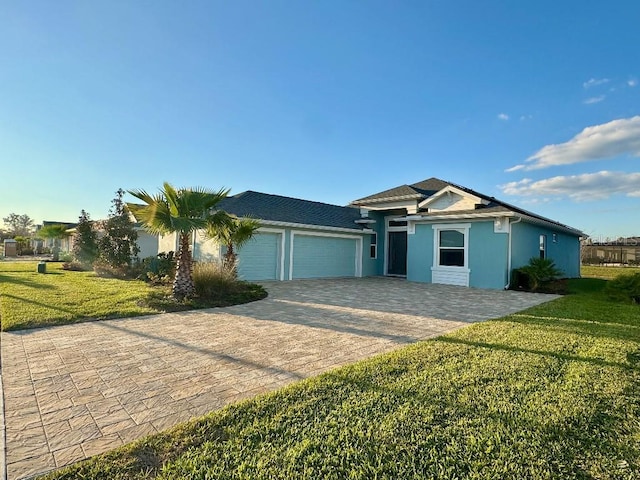 ranch-style house with a front yard, decorative driveway, an attached garage, and stucco siding