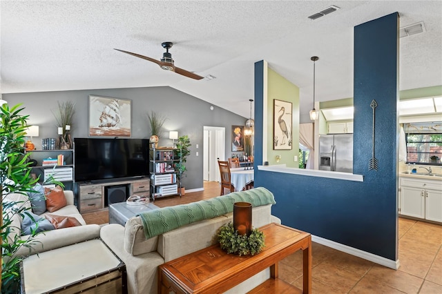 living room with light tile patterned floors, visible vents, lofted ceiling, ceiling fan, and a textured ceiling