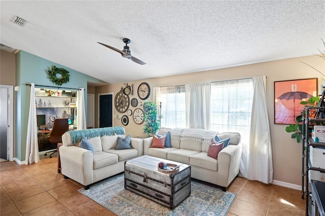 living area featuring visible vents, lofted ceiling, ceiling fan, tile patterned floors, and a textured ceiling