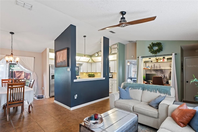 living room featuring lofted ceiling, tile patterned floors, visible vents, and ceiling fan with notable chandelier