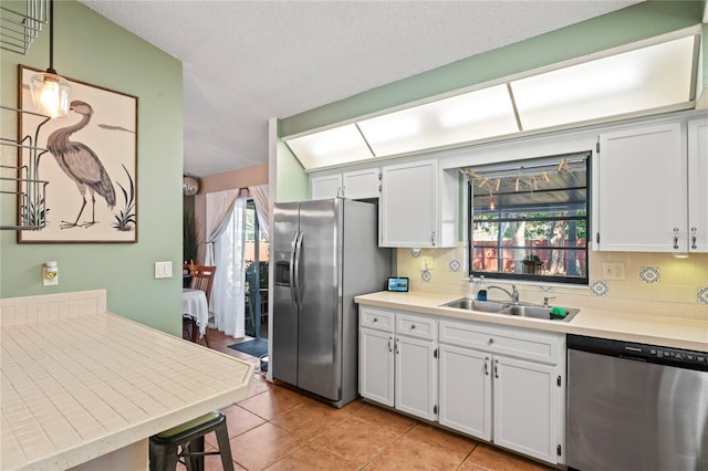 kitchen with stainless steel appliances, plenty of natural light, a sink, and decorative backsplash