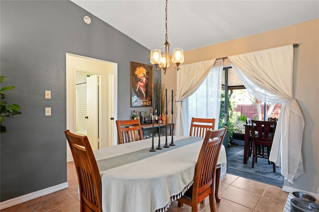 tiled dining area with lofted ceiling, a notable chandelier, and baseboards