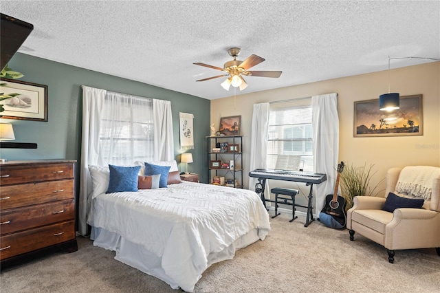 bedroom with a textured ceiling, a ceiling fan, and carpet flooring