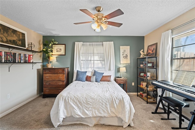 carpeted bedroom with ceiling fan, a textured ceiling, and baseboards