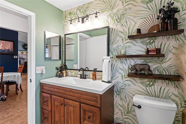 bathroom with wallpapered walls, toilet, tile patterned floors, ensuite bathroom, and vanity