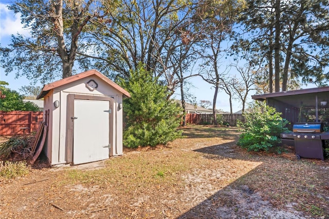 view of shed with fence and a sunroom