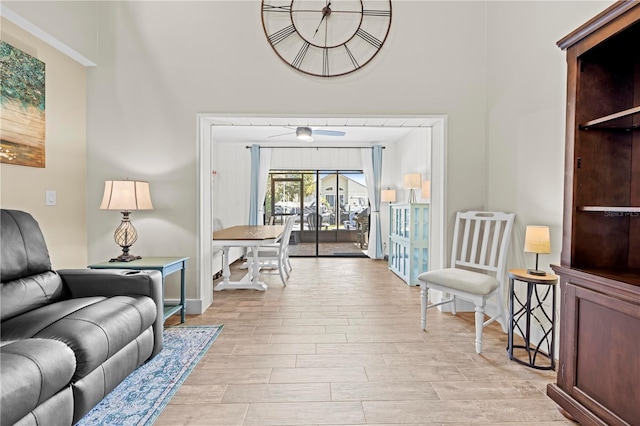 living room featuring a high ceiling, light wood-type flooring, and baseboards