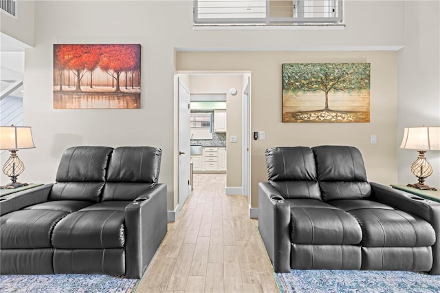 living room with baseboards, visible vents, and light wood-style floors