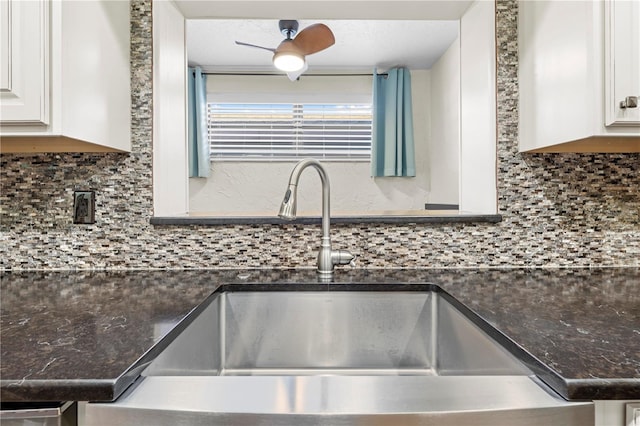 kitchen featuring ceiling fan, tasteful backsplash, dark countertops, and a sink