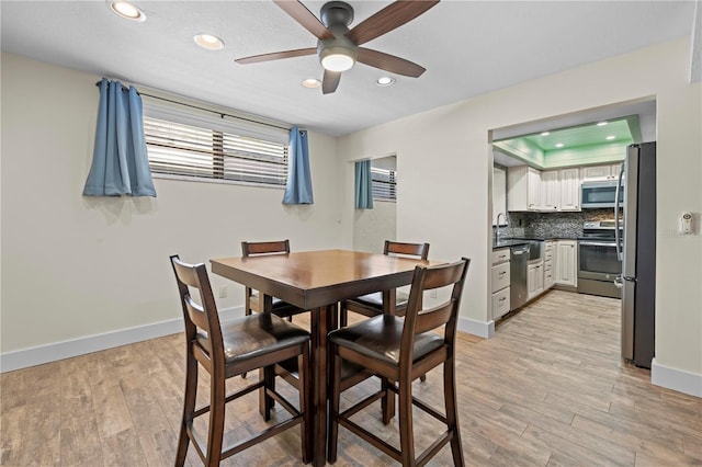 dining room with baseboards, recessed lighting, and light wood-style floors