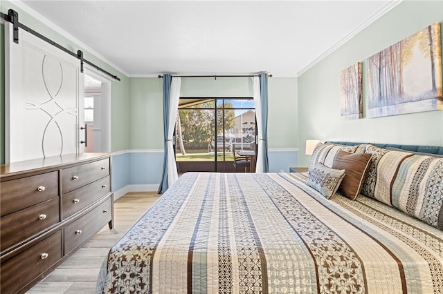 bedroom featuring access to exterior, a barn door, light wood-style flooring, and crown molding