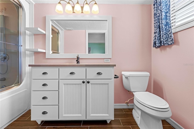 bathroom featuring toilet, wood tiled floor, enclosed tub / shower combo, and baseboards