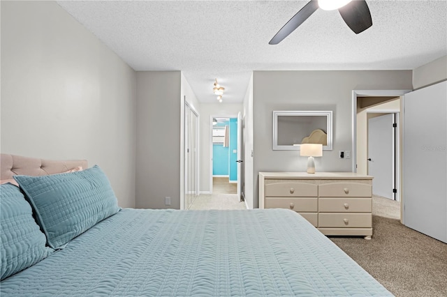 carpeted bedroom with a textured ceiling and a ceiling fan