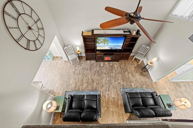 living area featuring ceiling fan, vaulted ceiling, and wood finished floors