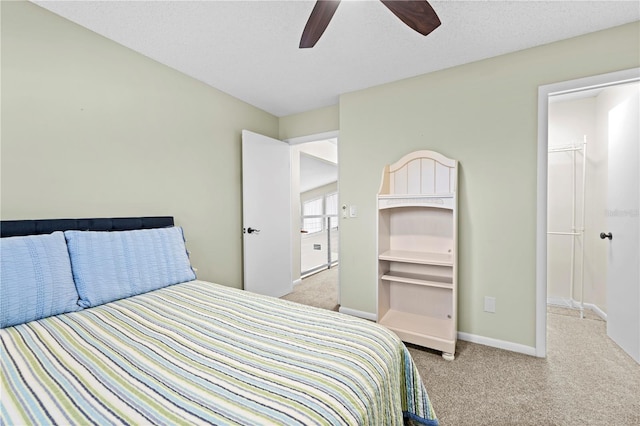 bedroom with a textured ceiling, carpet floors, a ceiling fan, and baseboards