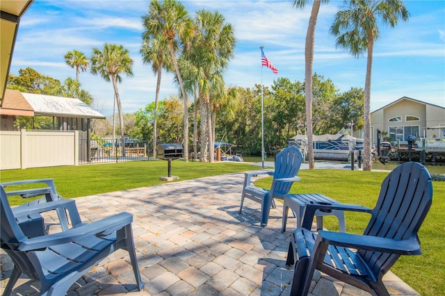 view of home's community with a boat dock, fence, a patio, and a yard