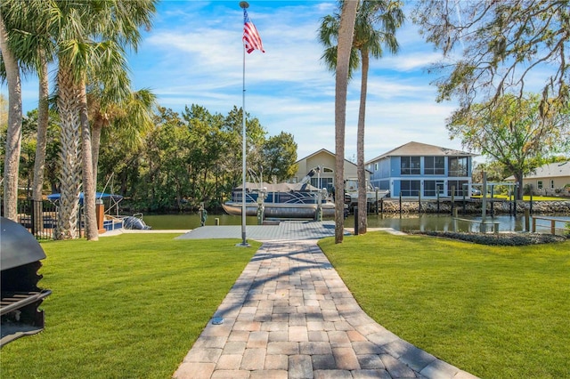 view of property's community featuring a boat dock, a water view, and a lawn