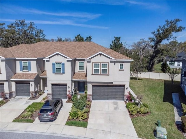 view of front facade featuring a garage, fence, driveway, stucco siding, and a front yard