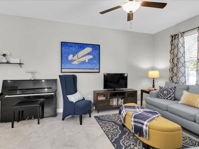 living area featuring tile patterned flooring, ceiling fan, and baseboards