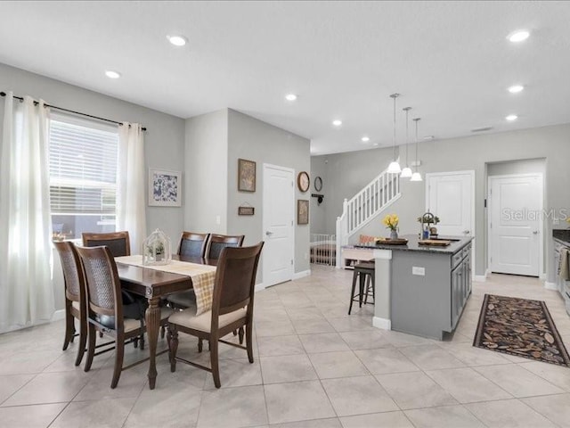 dining room featuring recessed lighting, light tile patterned floors, baseboards, and stairs