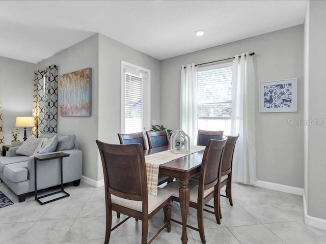 dining area featuring light tile patterned floors and baseboards