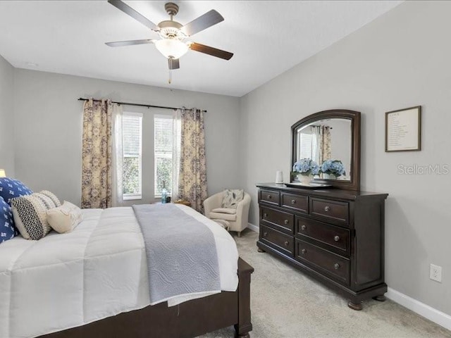 bedroom with light carpet, ceiling fan, and baseboards