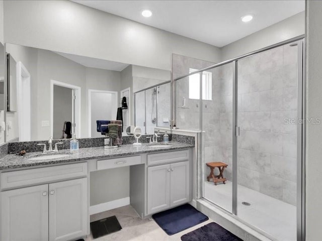 bathroom with double vanity, a sink, and a shower stall