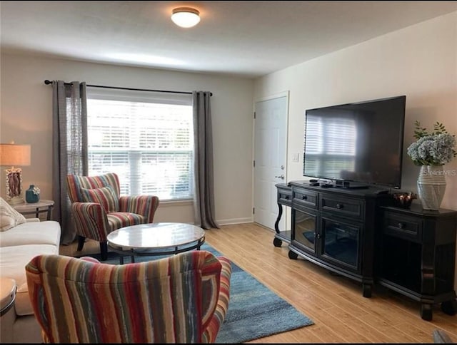 living room with baseboards and light wood-style flooring