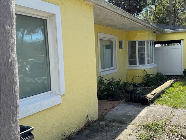 view of property exterior with fence and stucco siding