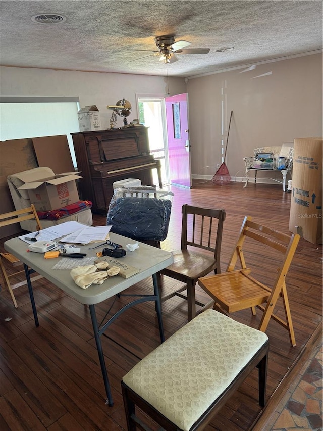 interior space featuring ceiling fan, a textured ceiling, visible vents, and wood finished floors