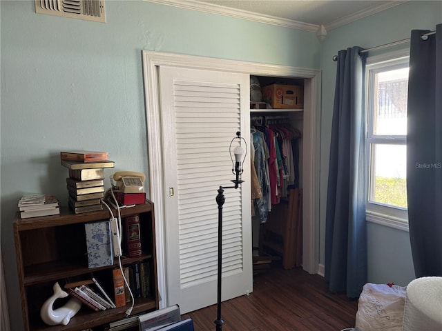 bedroom featuring ornamental molding, a closet, dark wood finished floors, and visible vents