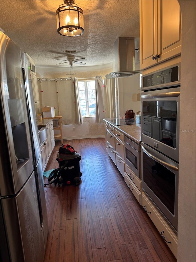 kitchen featuring dark wood finished floors, appliances with stainless steel finishes, a textured ceiling, baseboards, and exhaust hood