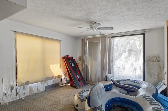 bedroom with ceiling fan and a textured ceiling