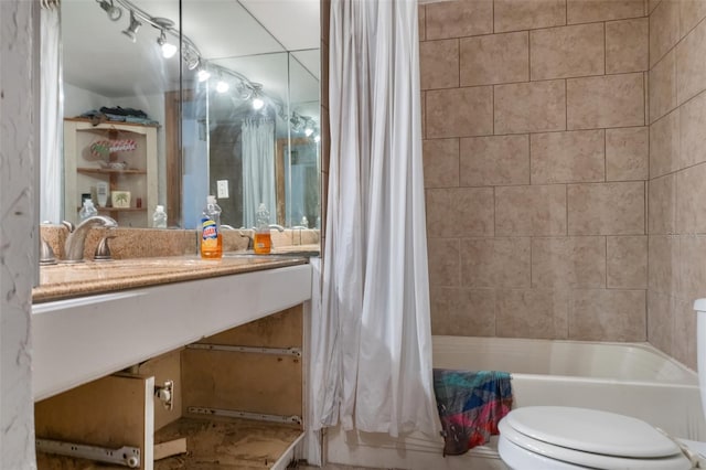 bathroom featuring toilet, shower / tub combo with curtain, and vanity