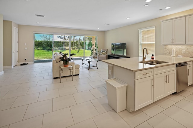 kitchen featuring visible vents, backsplash, light countertops, stainless steel dishwasher, and a sink