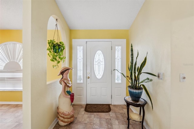 entryway with stone finish floor and baseboards