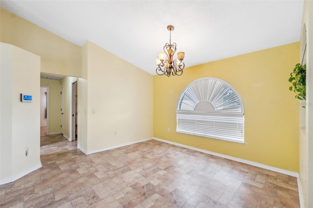 empty room featuring lofted ceiling, stone finish floor, an inviting chandelier, and baseboards