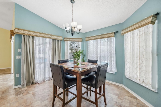 dining space with baseboards, stone finish flooring, vaulted ceiling, a textured ceiling, and a notable chandelier