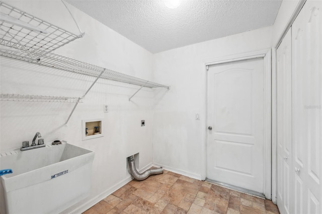 laundry area with hookup for a washing machine, stone finish flooring, a sink, electric dryer hookup, and laundry area