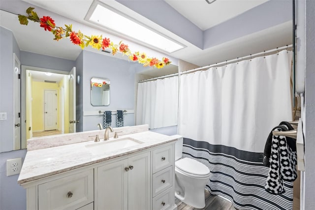 full bathroom with toilet, wood finished floors, and vanity