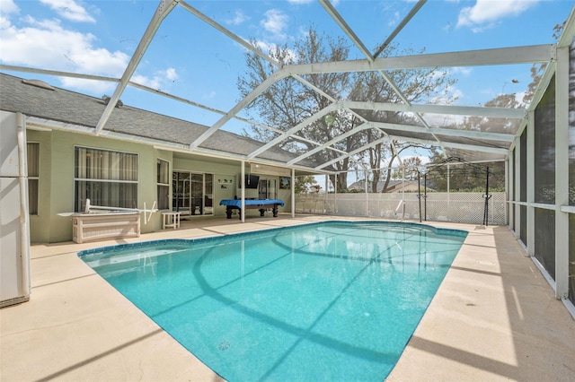 view of swimming pool with glass enclosure, fence, a fenced in pool, and a patio