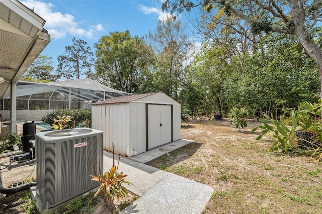 view of yard featuring glass enclosure, a storage unit, an outdoor structure, and cooling unit