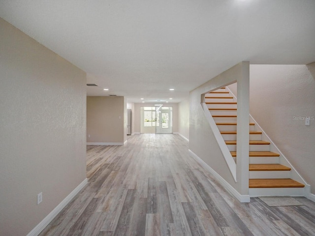 hall with stairway, baseboards, visible vents, and wood finished floors