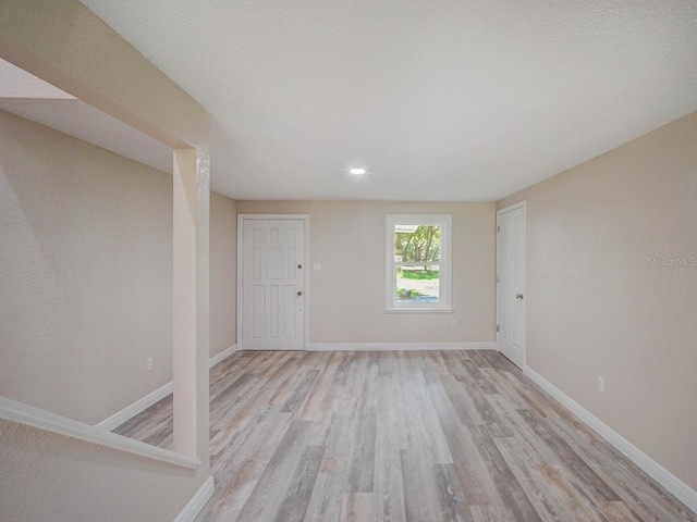 empty room with light wood-style flooring and baseboards