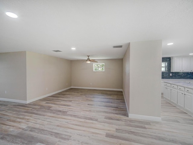 interior space featuring visible vents, light wood-style flooring, and a ceiling fan