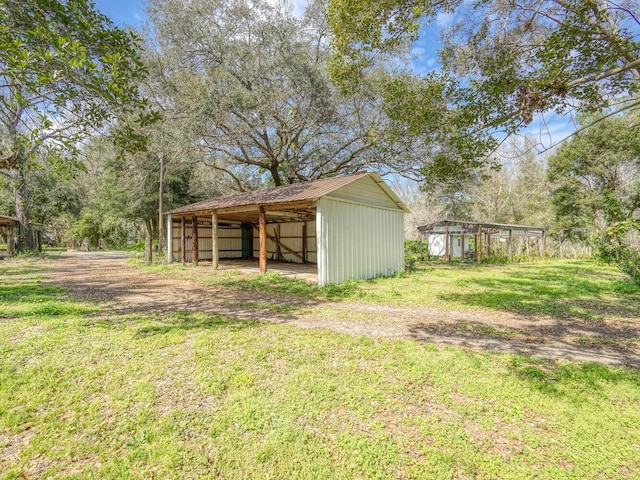 view of yard featuring an outbuilding, a detached carport, and an outdoor structure