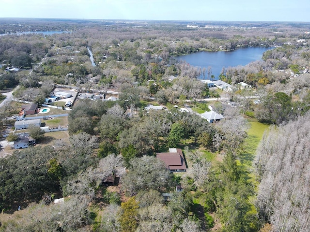 birds eye view of property with a wooded view and a water view