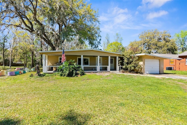 view of front facade with driveway, an attached garage, covered porch, a front lawn, and central air condition unit